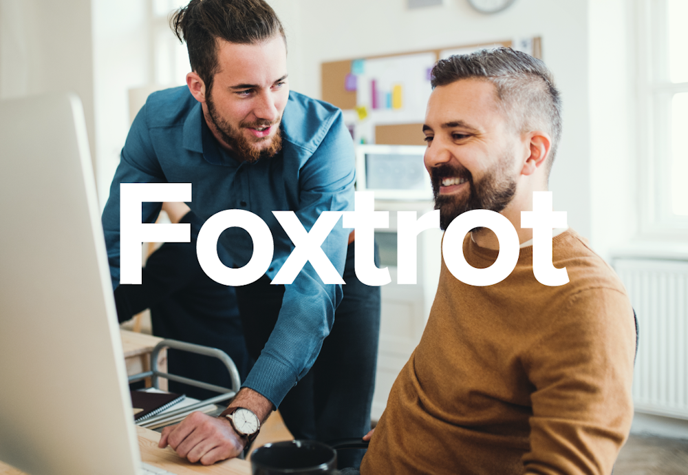 The Foxtrot Marketing Group brand design name over photo of two guys looking at a screen.