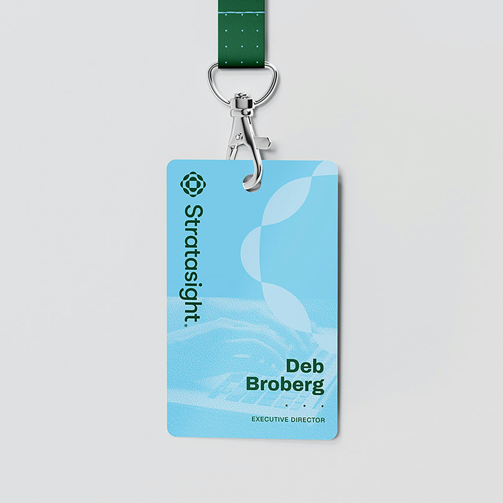 Stratasight logo badge: An example of the Stratasight logo and wordmark, developed by Capsule in Stratasight's 2026 rebrand, printed on an identification badge with the name of Executive Director Deb Broberg in the Stratasight brand typography.