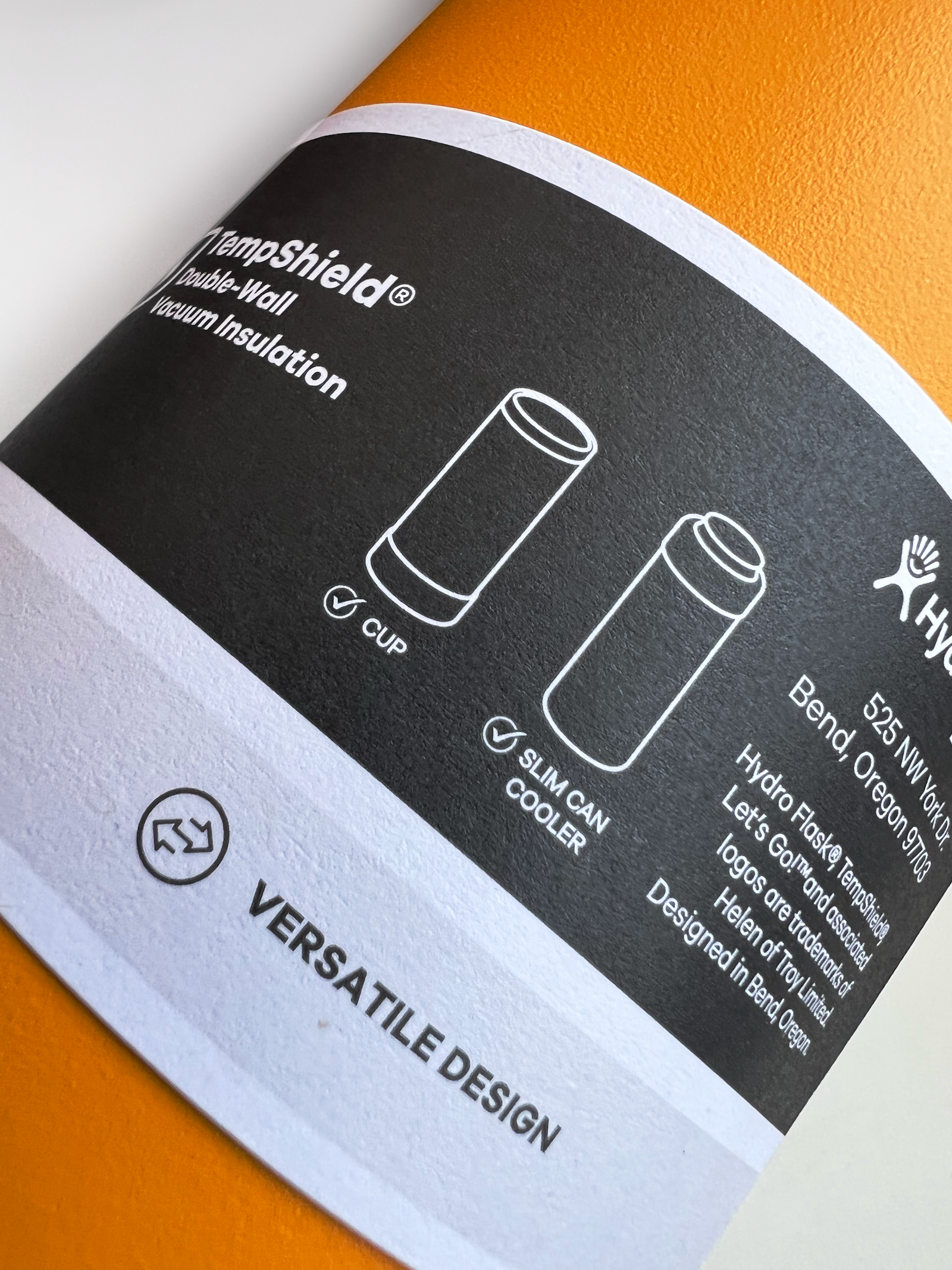 The Hydro Flask brand design packaging label on a orange flask in closeup photo.