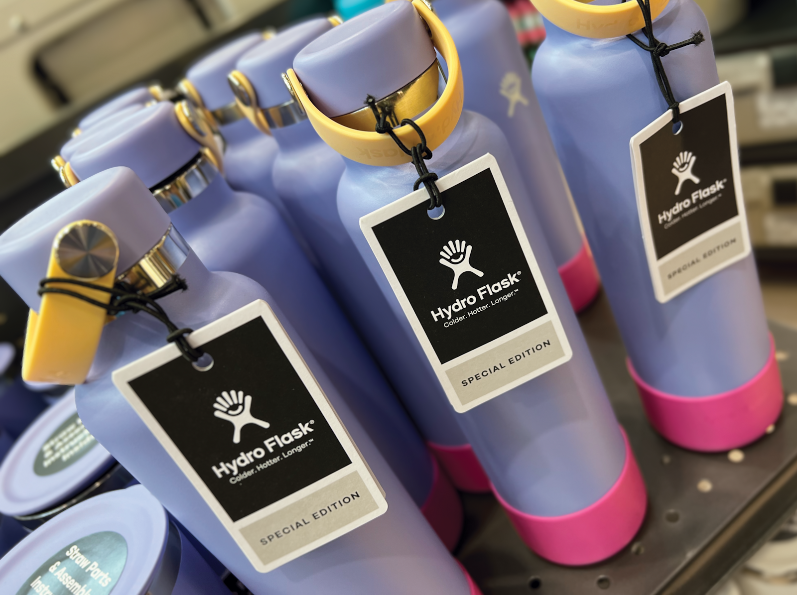 The Hydro Flask brand design hang tag on bottles in retail display.