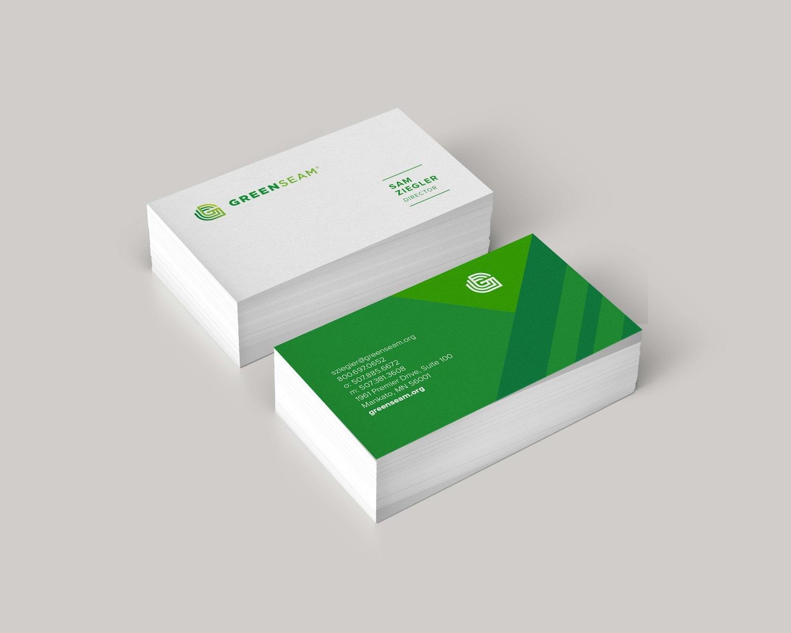 The GreenSeam brand logo design business cards in a stack on a white surface.