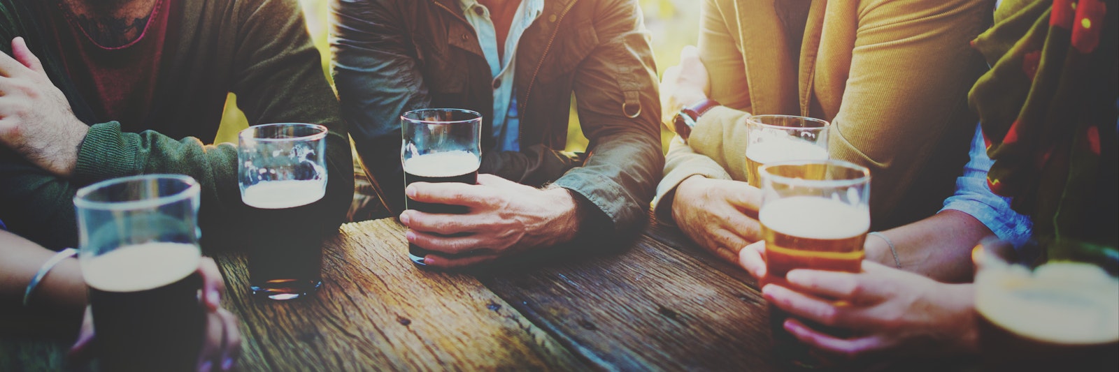 A table of people at a brewery drinking beer for a brewery's photography style and branding.