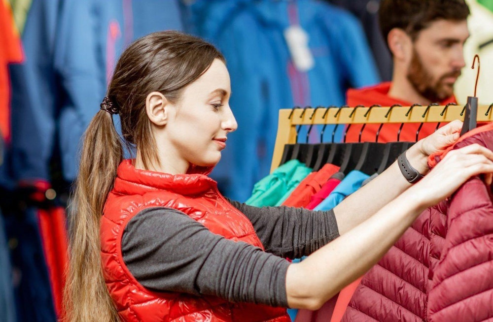 The Patagonia brand packaging design photo of woman shopping for coat in retail display.